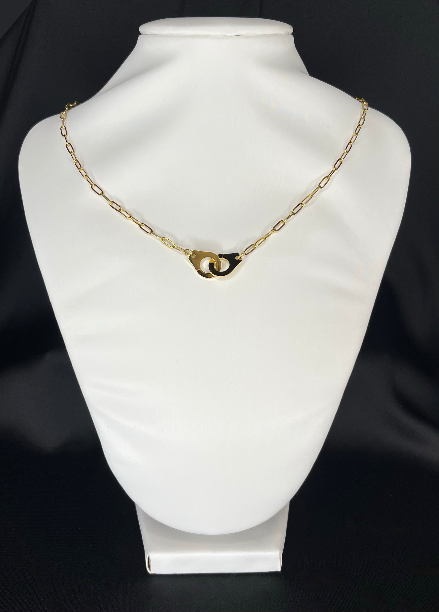 Photo d'un collier menottes doré. Ce collier est composé d'une chaîne avec des mailles ainsi que d'une paire de menottes. Ce collier menotté est en acier inoxydable ce qui signifie qu'il résiste à l'eau et à la corrosion. 